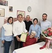 Nonna Rosa Valzania in festa per i 100 anni con la famiglia e il parroco don Stefano Pasolini