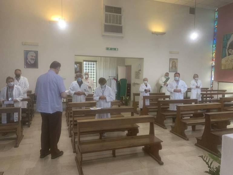 Don Fiorenzo Castorri benedice i ministri straordinari dell'Eucaristia prima di avviarsi ai reparti. La foto è stata scattata ieri mattina