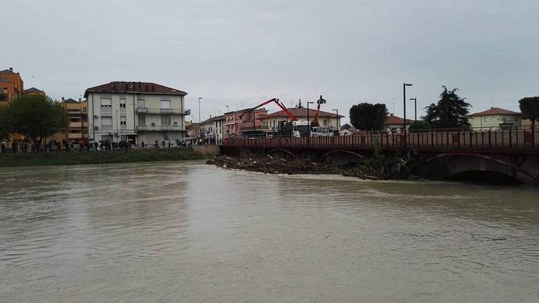Un'immagine scattata oggi al Ponte nuovo. Il fiume Savio in piena e i lavori per cercare di liberare le arcate dai detriti arrivati a valle