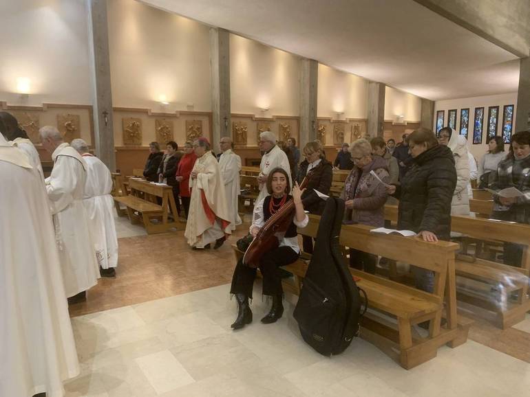 Il vescovo Douglas mentre si avvia all'altare. Davanti le donne ucraine intente nel canto iniziale