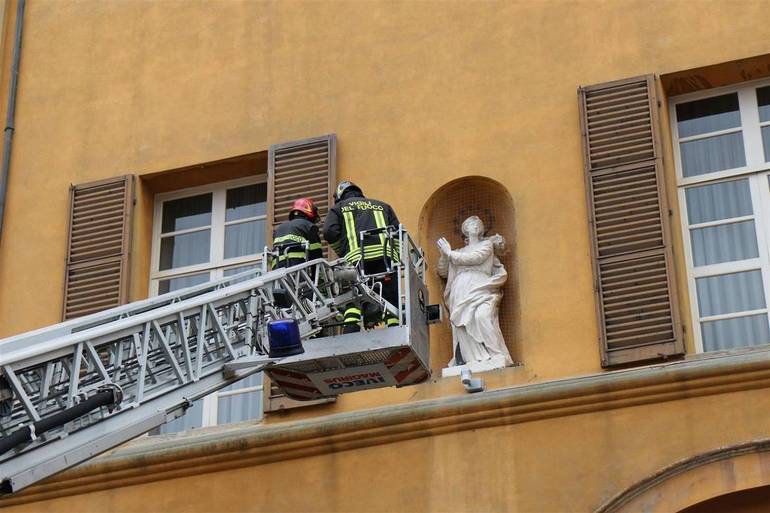 Nella foto i vigili del fuoco portano una corona di fiori alla statua della Madonna Immacolata posta sul palazzo comunale, a Cesena (Foto P.G. Marini)