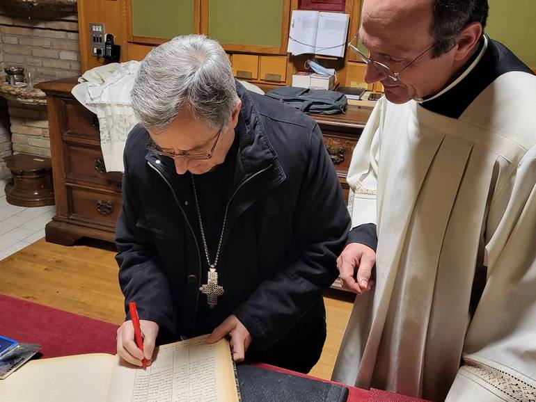 Monsignor Regattieri firma il registro delle celebrazioni
