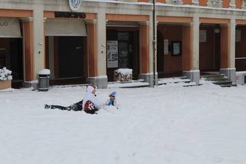 Bambini giocano fra la neve in piazza Tre Martiri