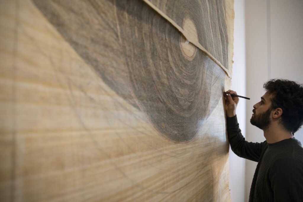 Gianluca Bosi al lavoro al suo arazzo di nove metri. Le foto sono di Matteo Bosi