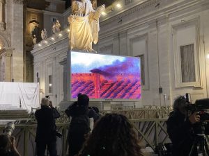 Sul maxi schermo in piazza San Pietro, con la gente ormai tutta sciamata, sotto la Cappella Sistina, con il comignolo che manda un segnale di fumo nero. Il Papa al primo scrutinio non è stato eletto.